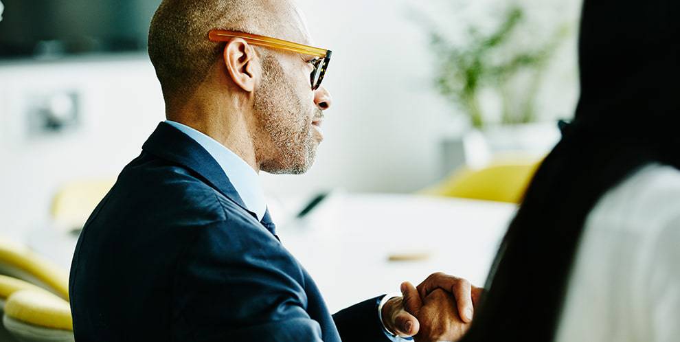 Man with glasses listening in a conference room